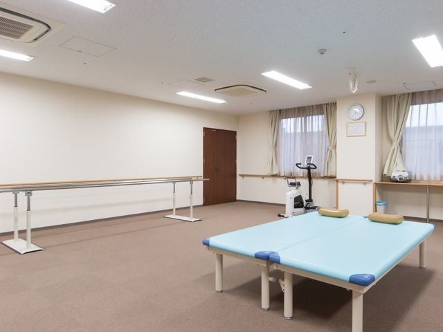 リハビリ訓練用具のある部屋 機能訓練室 様々なリハビリ機器を備え、利用者の身体機能向上をサポートする空間です。明るく清潔感のある環境で、日々の健康維持に役立ちます。