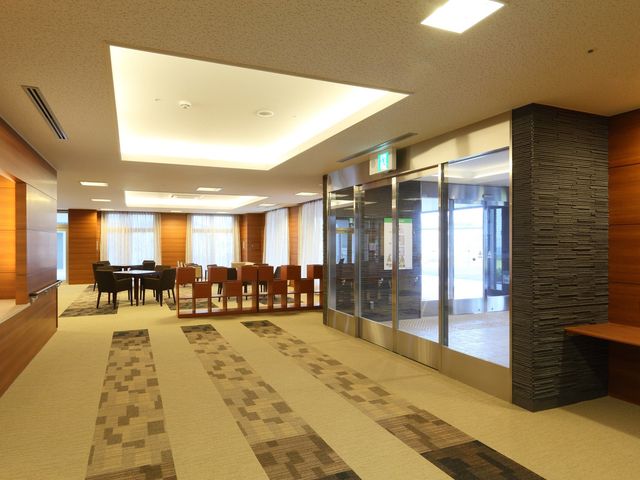 明るく広々としたロビー 玄関ロビー 広々として開放感のあるロビーは、来訪者を暖かく迎え入れます。ゆったりとした椅子が配置され、交流の場としても利用できます。