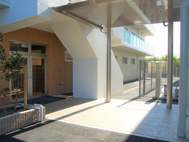明朗なエントランス風景 施設と病院を繋ぐ通路 広々としたエントランスは自然光がたっぷり差し込み、訪れる皆さまを明るく迎えます。安心感あるデザインは、日々の出入りも快適です。