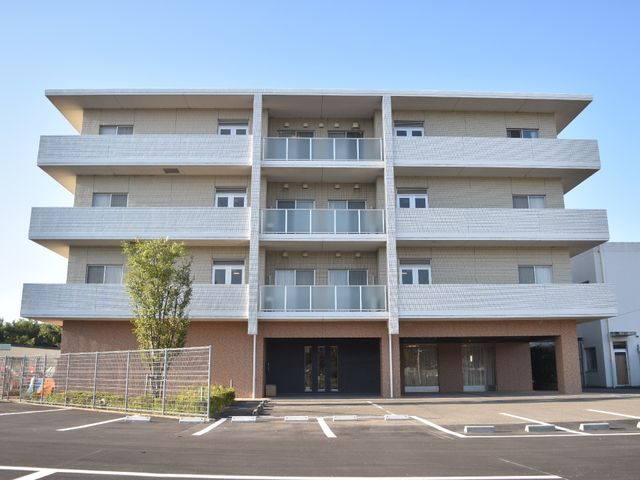 モダンな施設の外観 外観・周辺環境 清潔感のある明るい建物が迎える、快適にお過ごしいただける職場です。広々とした駐車場も完備しており、通勤も便利です。