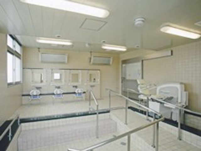 浴室の設備 浴室 明るく清潔感のある空間で、利用者が安心して入浴できるように設計されています。座りやすいベンチも配置されています。