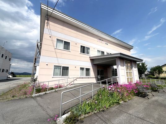 花に囲まれた建物外観