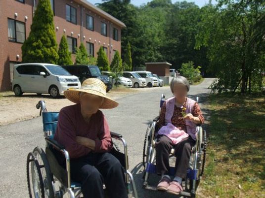 車椅子の方々と施設外観