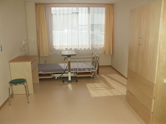 ベッドと明るい居室 居室 日当たりの良い居室は、落ち着いた空間で快適な生活をサポートします。