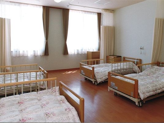 明るい居室に並ぶベッド  