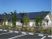 サムネイル 施設の写真 木造平屋建て介護付き有料老人ホームである。自然豊かで閑静な住宅地に立地する。駐車場を完備し、青い屋根が空に映えている。