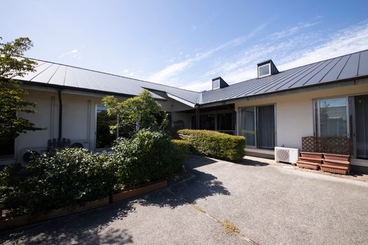 緑に囲まれた一階建て建物