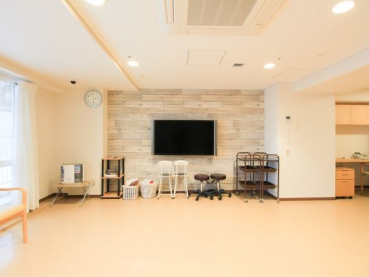 空調の付いた広い部屋があり、壁に大型テレビが設置されている。テレビの近くには、回転椅子やキャスター付きのワゴンが並べられている。