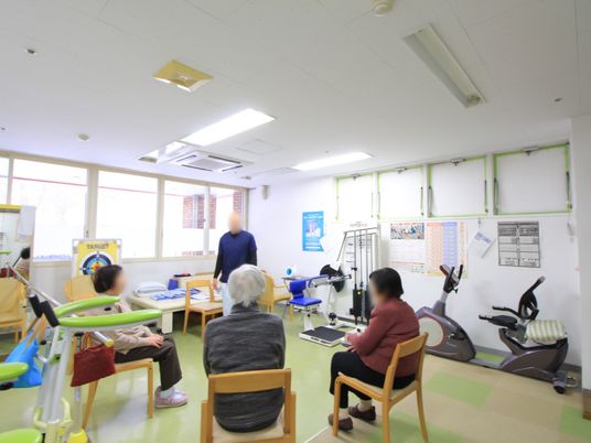 淡い緑色の床で爽やかな印象の部屋に、各種トレーニング器具が設置されている。専任スタッフの指導のもと個別及び集団リハビリを行っている。