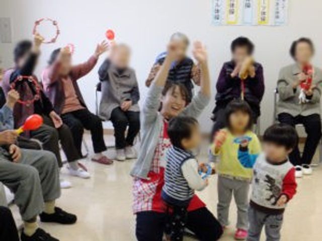 楽しい交流の場 多目的室 お年寄りと子供たちが楽しく交流しています。和やかな雰囲気の中、楽しいひとときが共有されています。