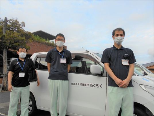 送迎車前のスタッフ  