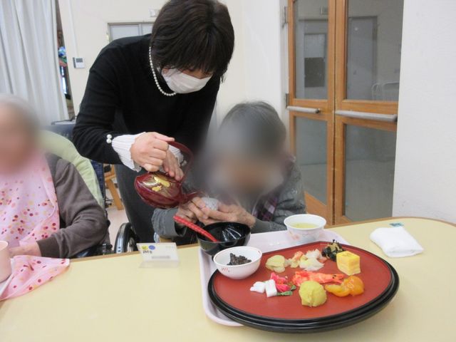 和やかな食事風景 リビング 和気あいあいとした食事が楽しめるスペースです。スタッフが親切に対応している様子が見受けられます。