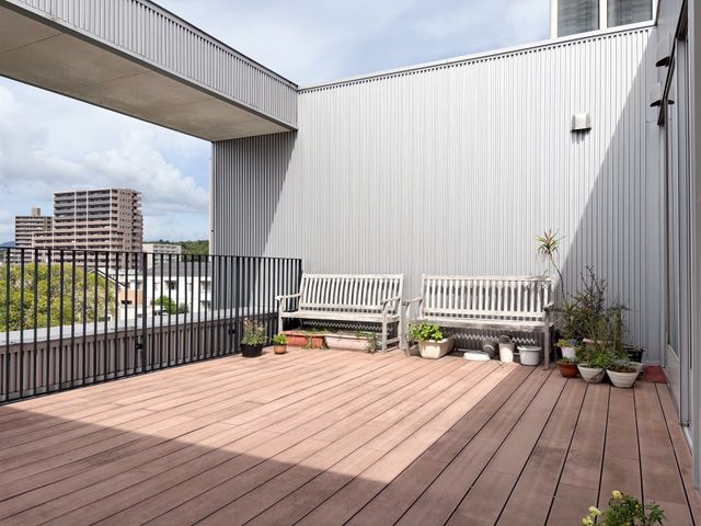 木製ベンチのテラス テラス 広々としたテラスには、木製ベンチが配置され、緑の鉢植えが並んでいます。自然光の中でゆったり過ごせます。
