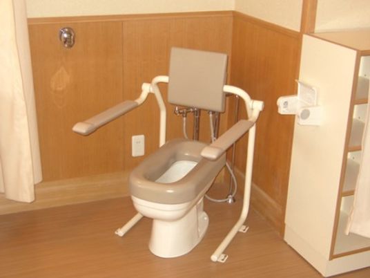 トイレの便器には、背もたれパッド付き可動式手すりが設置されている。安全に体勢が維持でき、移動にも安心である。