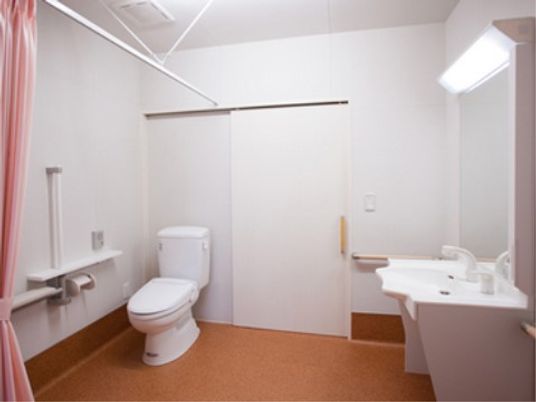 施設の写真 ゆとりあるスペースに完備されているトイレには、車椅子をご利用の方の足元にも配慮あるデザインの洗面台が設置されている。