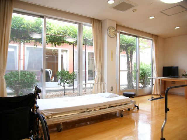 明るい居室と窓の外景色 居室 ゆったりとしたベッドと窓際の座席があり、外の風景を望むことができる癒しの空間です。