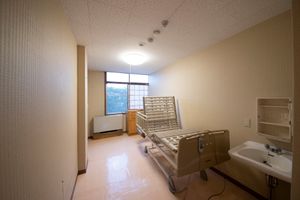 居室の空のベッドと洗面所