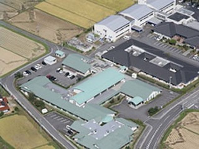 緑の屋根の建物外観 外観 緑の屋根が特徴的な建物は、広々とした駐車スペースを備えています。周囲には田んぼが広がり、落ち着いた環境です。