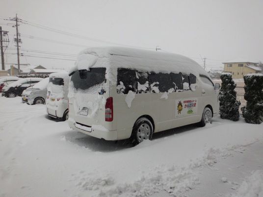 雪に覆われた送迎車の駐車場  