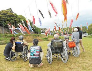 利用者が外で鯉のぼりを見る