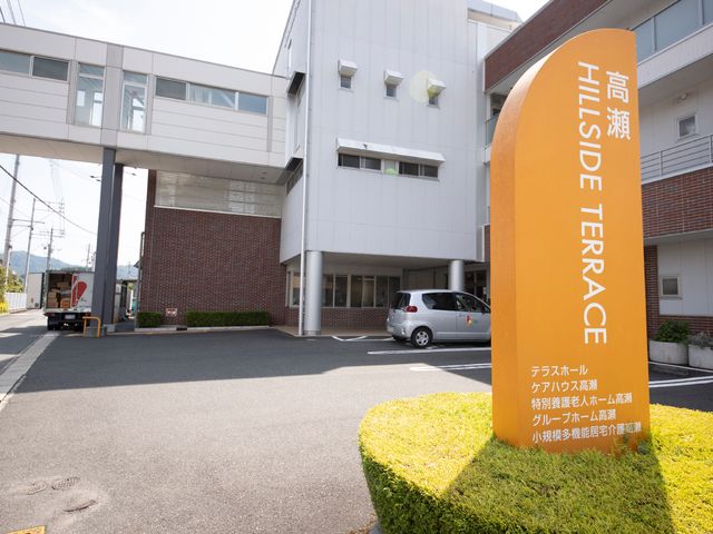 施設の外観と看板 駐車場 ゆとりのある外観のこの施設は、静かな住宅街に位置しており、落ち着いた環境でのお仕事が可能です。