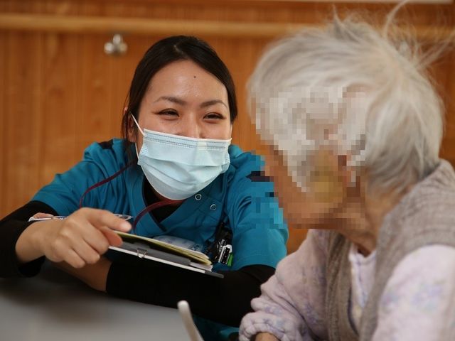 スタッフとの対話 スタッフイメージ 優しげなスタッフが親身に利用者と談笑しています。暖かい対応が特徴的です。