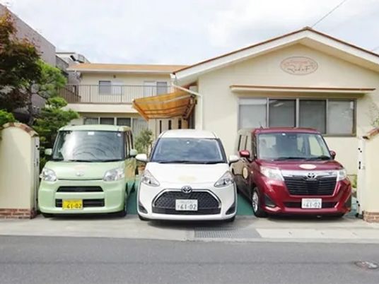 車が並ぶ施設外観  