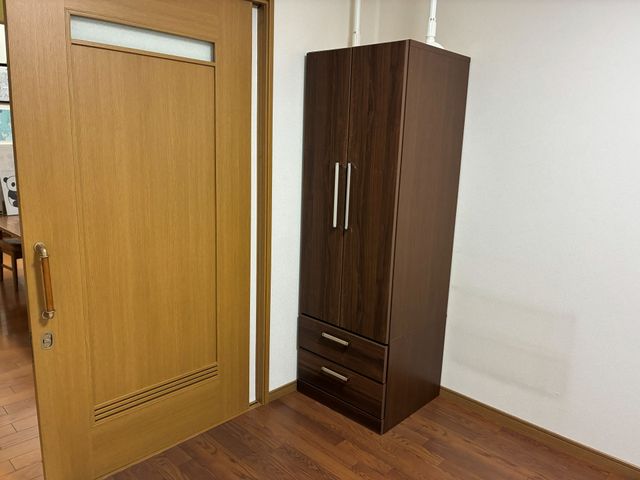 木目調の居室入口と収納 居室 木目調の扉と収納家具が並ぶ、落ち着いた居室です。すっきりした空間で、使いやすさを重視したつくりに見えます。