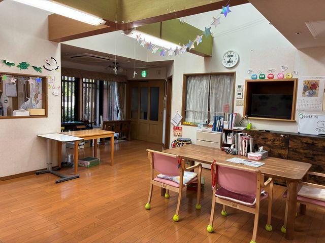 明るい食堂の様子 食堂   木目調の落ち着いた食堂で、テレビや掲示物があり、家庭的な雰囲気です。窓から光が入り、くつろぎやすい空間になっています。