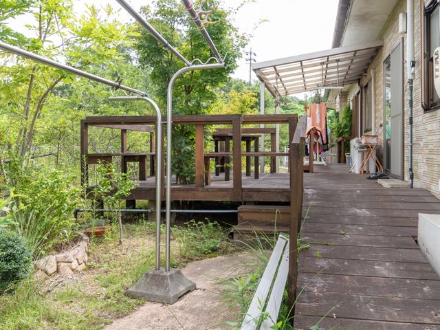 緑豊かな中庭の風景 ウッドデッキ 緑に囲まれた開放的な中庭は、自然の息吹を感じながら心地よい時間を過ごせる場所です。木製のデッキがあり、外気を楽しむのに最適です。