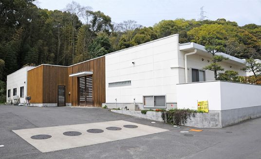 緑に囲まれた建物の外観  