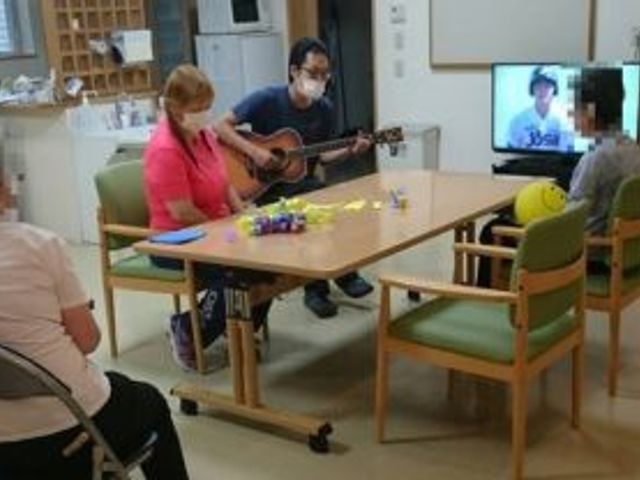 みんなで楽しむ様子リビング リビング   アットホームな雰囲気で、住人がリラックスして過ごせる交流の場です。ギター演奏を楽しんでいます。