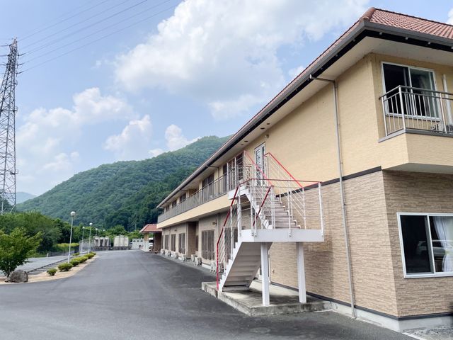緑豊かな施設の外観 外観 美しい山と自然に囲まれた施設は、心地よい静けさと開放感があります。リラックスした環境で働けます。