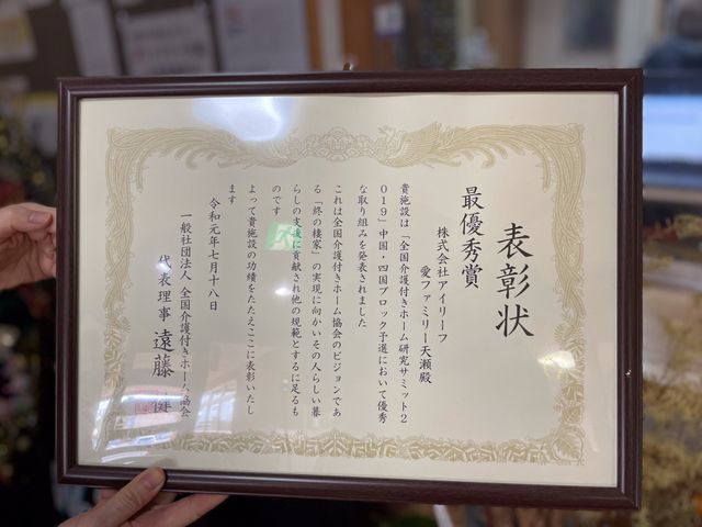 表彰状を持つ手 掲示物 優れた取り組みが評価された事を示す表彰状です。頑張りが認められる場面を目にできます。