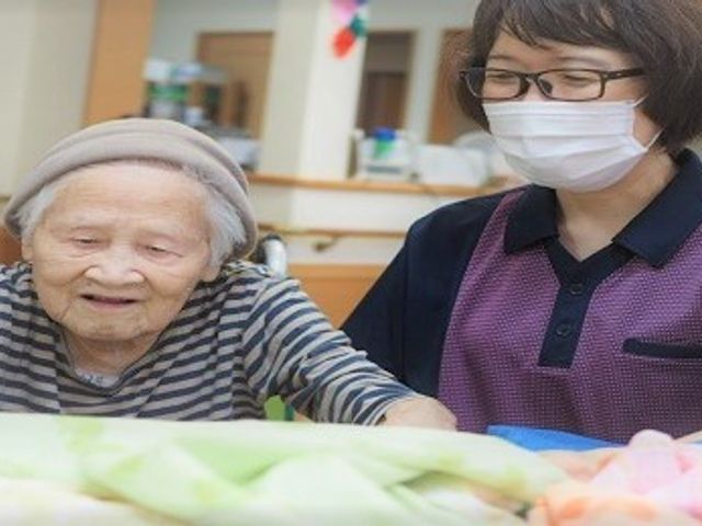 和やかな三人のスタッフイメージ 中庭 明るい笑顔のスタッフが活躍する環境。日々の業務を通して、利用者様の喜びを直接感じられる仕事です。