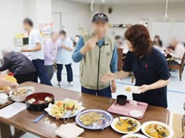 食を楽しむ交流スペース ダイニングルーム 明るく広々としたスペースで、利用者の方々が楽しく食事をされています。リラックスできる環境です。