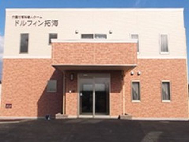 施設の正面玄関 外観   明るい外壁とすっきりした入口が印象的です。就業先として、来訪者を迎えやすい雰囲気が伝わります。