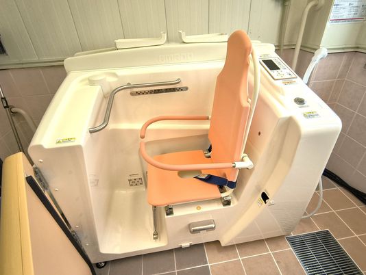入浴用機器と座席のある浴室  