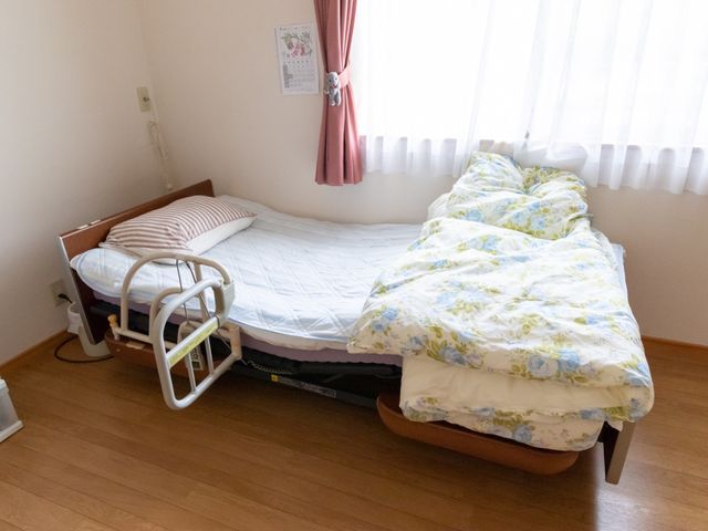 快適な居室のベッド 居室 ゆったりとしたベッドが配置された居室です。落ち着いた色合いで、安心して休息を取ることができます。