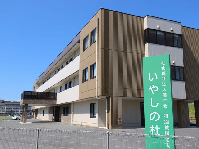 看板前の建物外観 外観 広々とした施設の外観は、明るい日差しが入り安心感があります。清潔な環境で働きやすさを感じられます。