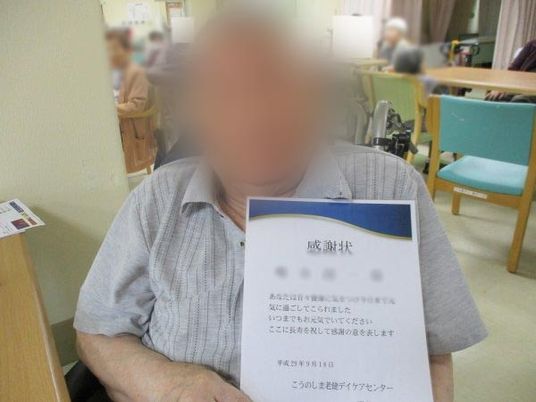 感謝状を手に持つ人
