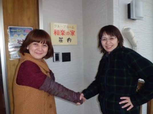 案内板前で握手する二人の女性がいるエントランス  
