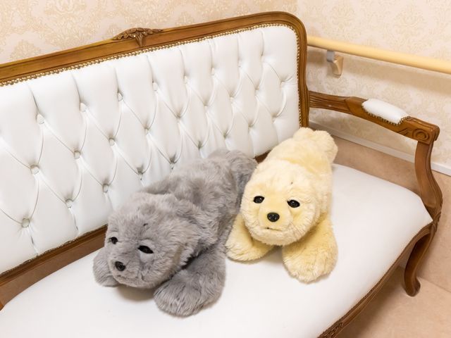 ぬいぐるみがある居室 ソファー 優しい色合いの居室には、くつろぎのひと時を演出するぬいぐるみが置かれ、温もりのある空間を提供しています。