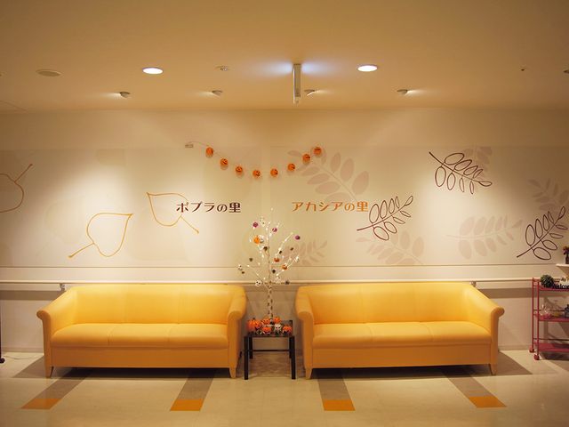 明るい共用スペース ラウンジ 壁がデザインされた、開放的で温かな雰囲気の共有スペースです。くつろぎのひとときを。