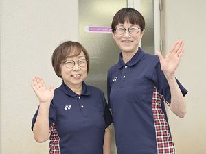 笑顔で手を振る職員2人  