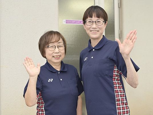 笑顔で手を振る職員2人  