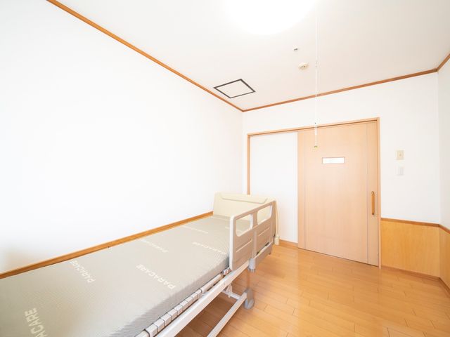 居室のベッドとドア ベッド ゆったりとした居室には、快適なベッドが配され、温かみのある色合いが落ち着いた雰囲気を演出しています。