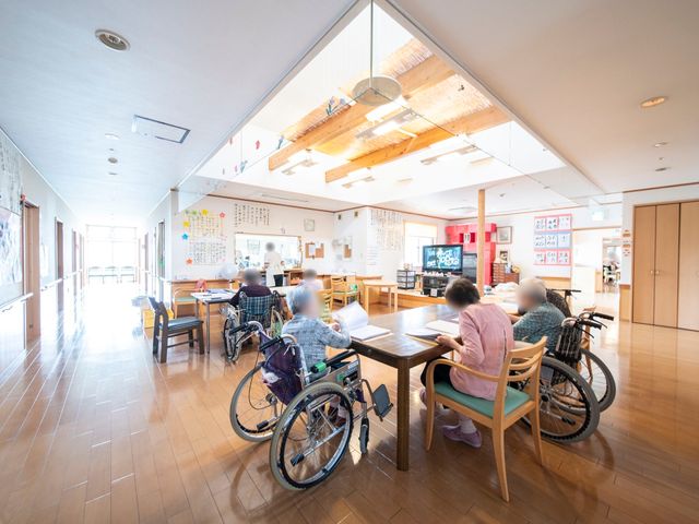 共有スペースの利用風景 食堂 広々とした食堂では、車椅子の方々もゆったりと過ごしています。木のぬくもりあふれる明るい空間で、皆さまの交流が見られます。