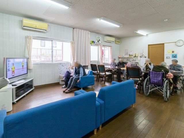 共有スペースの居心地良い様子 共有スペース リビングでは、入居者の皆さんがソファでくつろぎながらテレビを楽しんでいます。広々とした空間で、日々の憩いの時間を提供しています。