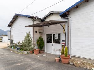 白壁の建物入口と草花